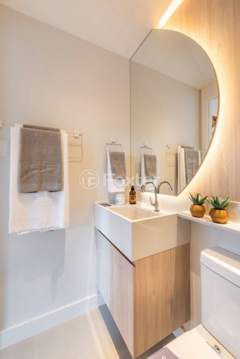 banheiro-moderno-com-lavabo-de-madeira-clara-e-espelho-oval.jpeg