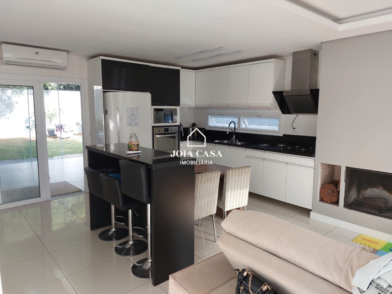 Cozinha com móveis planejados e forno embutido integrada com o ambiente da sala .