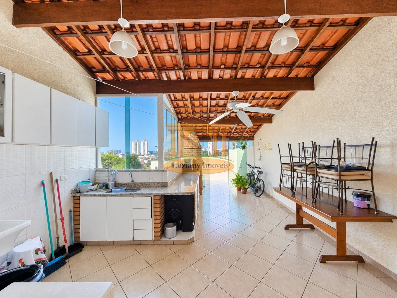 Área gourmet coberta com bancada e espaço para mesa