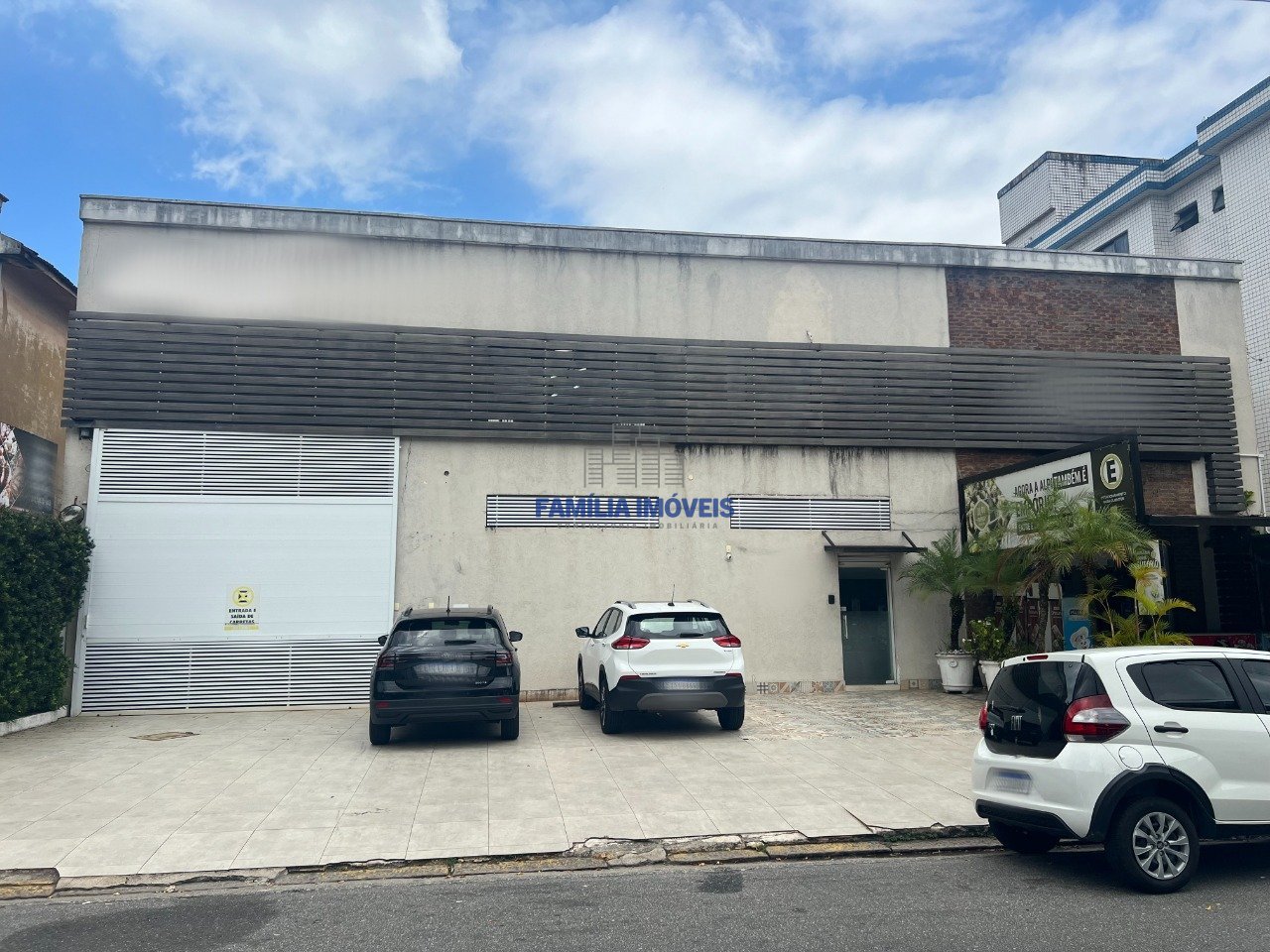 Fachada principal, com loja moderna, entrada para o escritório e estacionamento p/ ao menos 8 carros